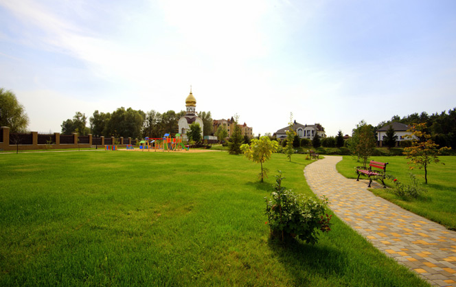 фото місцевого парку та виду на церкву, будинки і дитячий майданчик