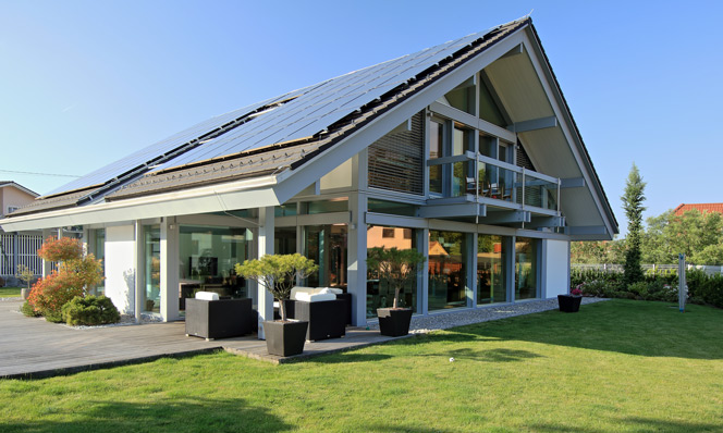 Сучасний фахверковий хай тек будинок з розташованими на даху сонячними батареями і з панорамним склінням по периметру будинку